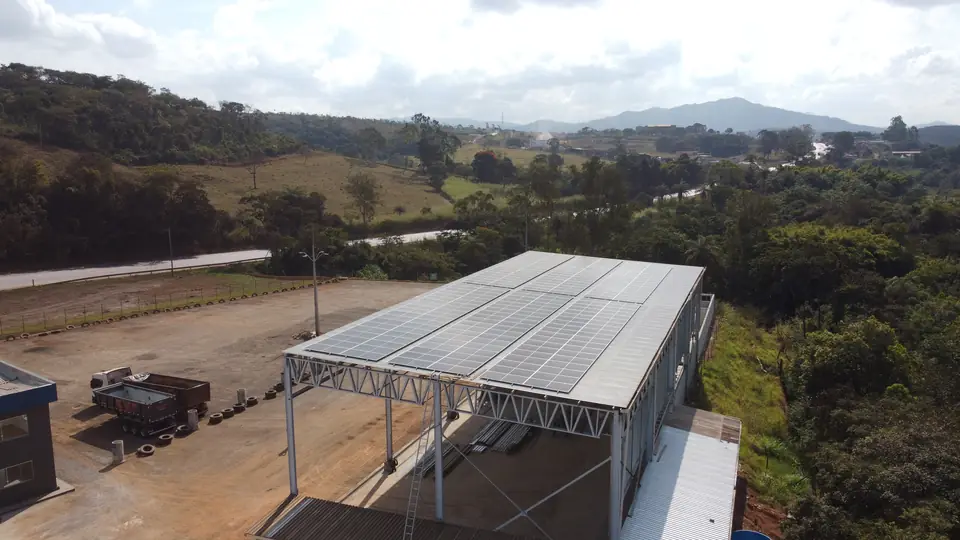 Galpão com usina solar na cobertura e a paisagem de Minas Gerais ao fundo